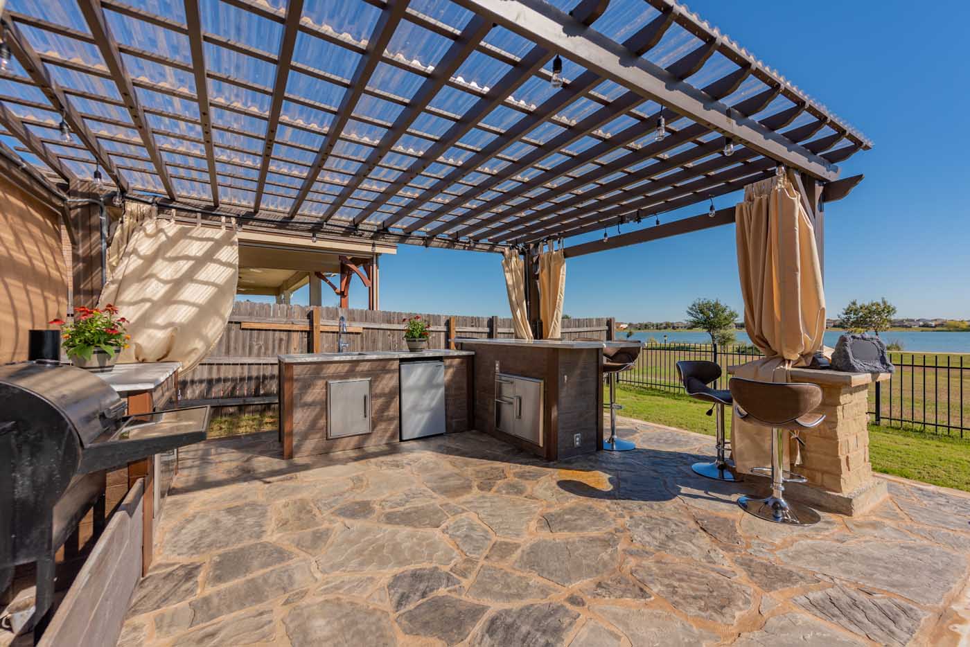 an outdoor summer bar kitchen underneath a pergola in